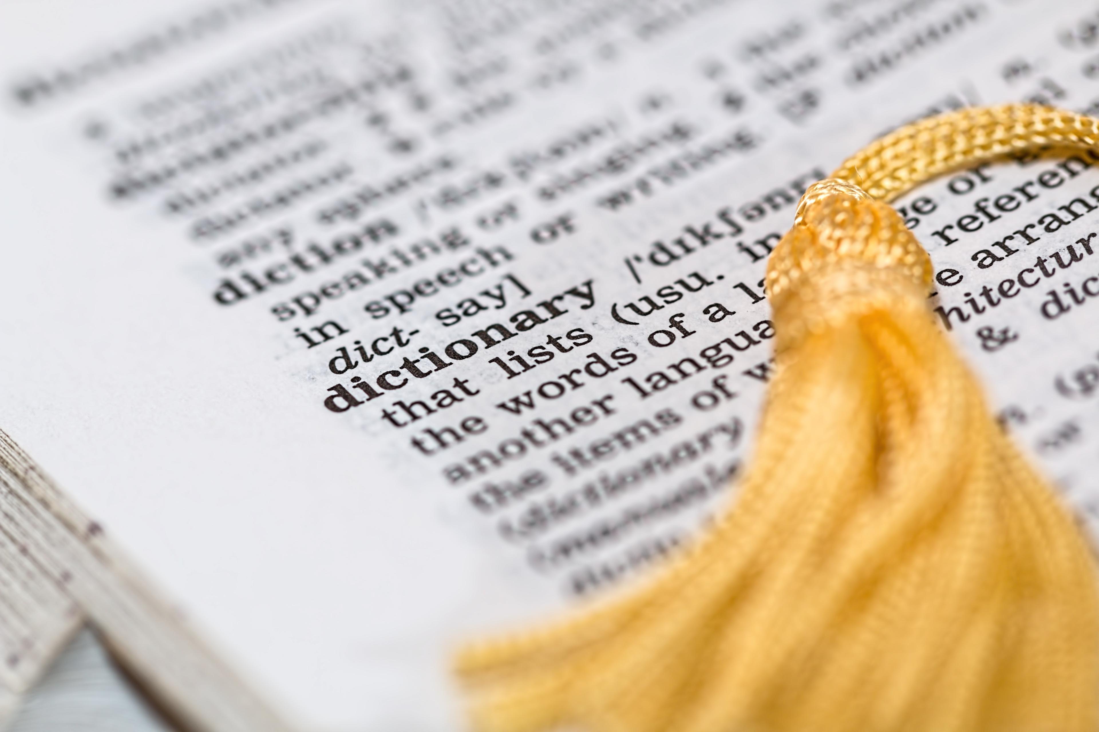 A dictionary page with a gold bookmark tassel