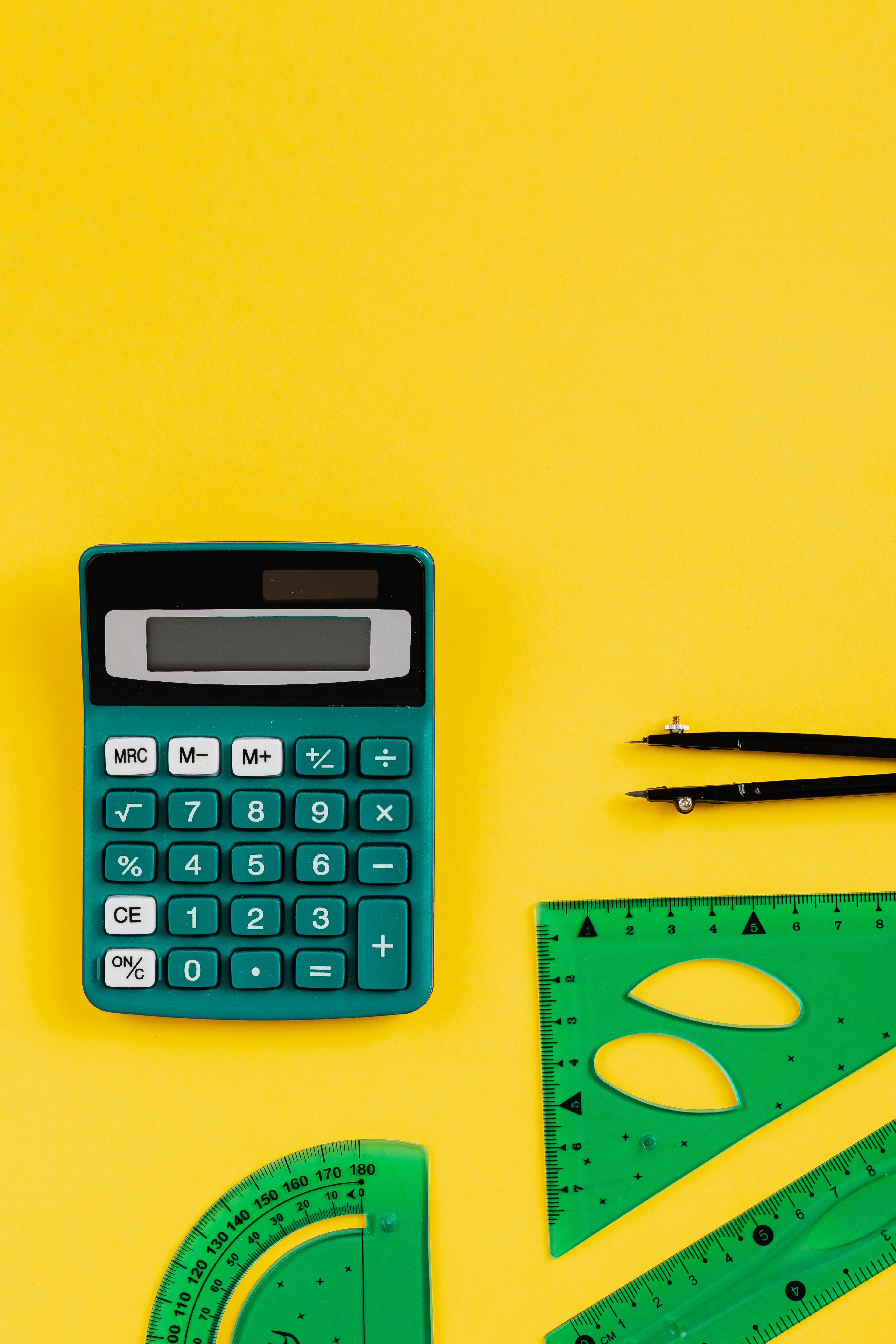 Maths supplies: a calculator, rulers and a drawing compass